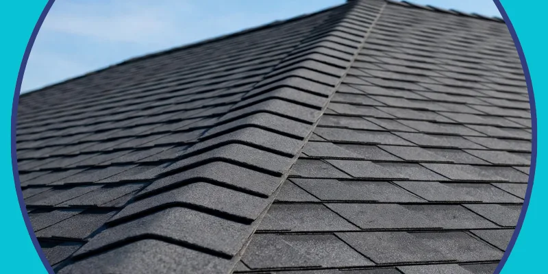 Close-up view of a newly installed dark gray architectural asphalt shingle roof ridge